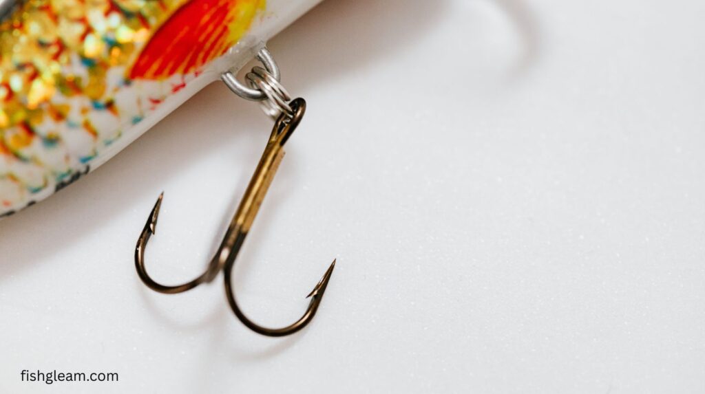 Treble hook hanging from a fishing lure, showing sharp points used for secure hook sets